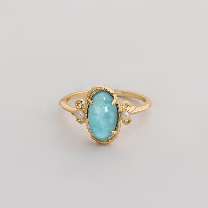 A gold vermeil band ring with a large teardrop-shaped larimar stone set in a gold vermeil setting