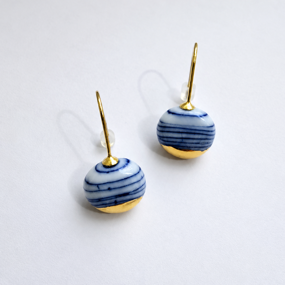 Pair of earrings with blue and gold design on a white background