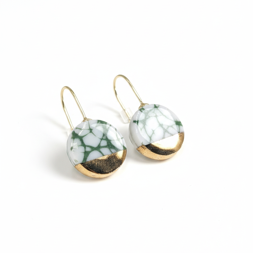 Pair of earrings with marbled design and gold accents on a white background