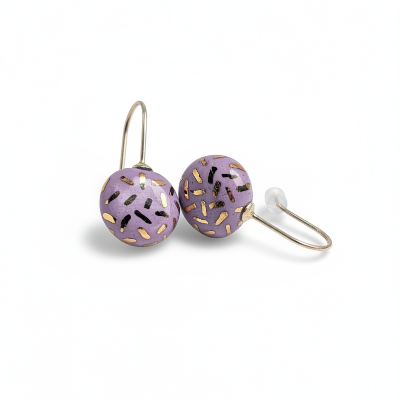 Pair of purple earrings with gold accents on a white background