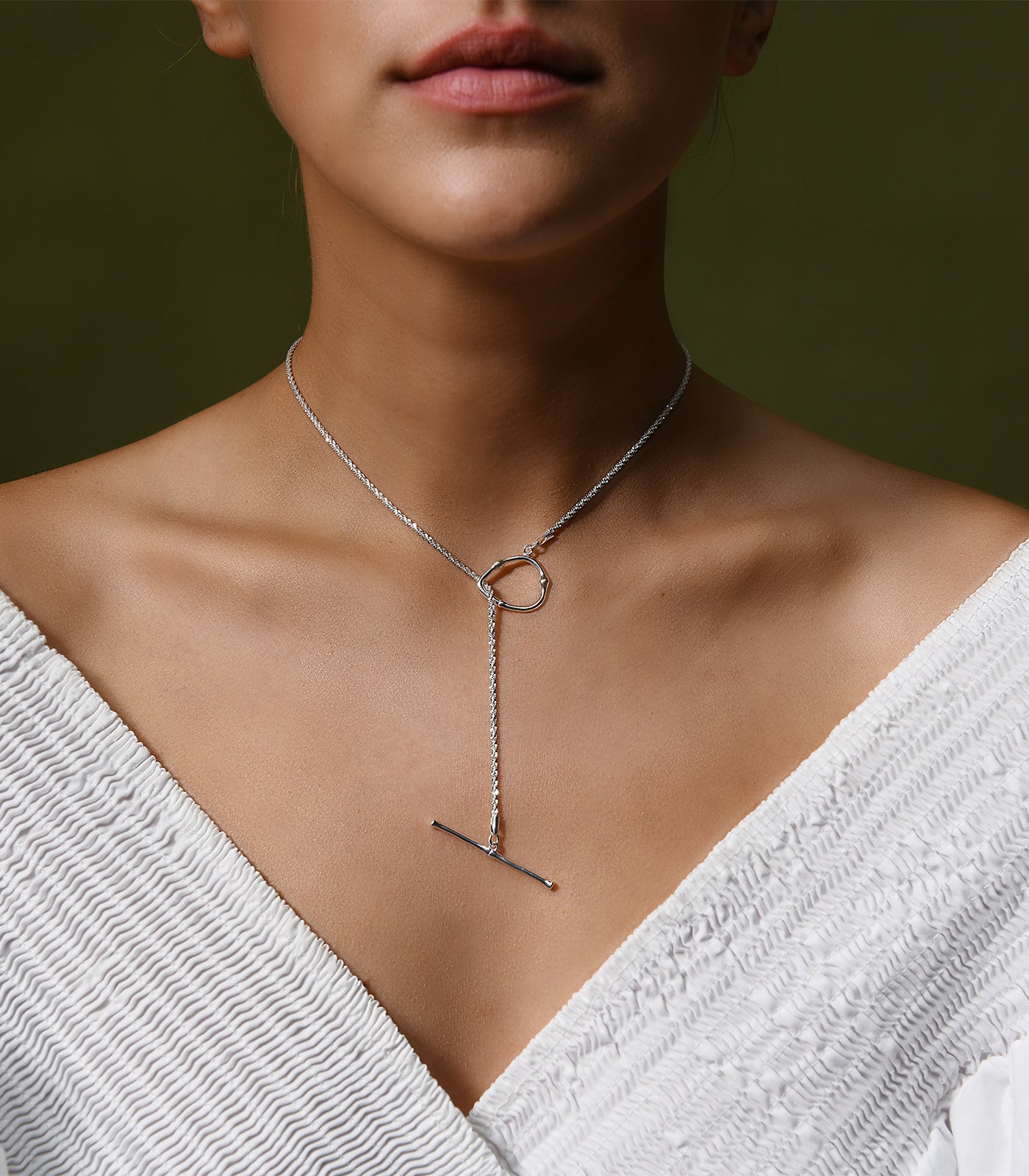 A shimmering, sterling silver toggle clasp necklace. The toggle clasp design is worn at the front.