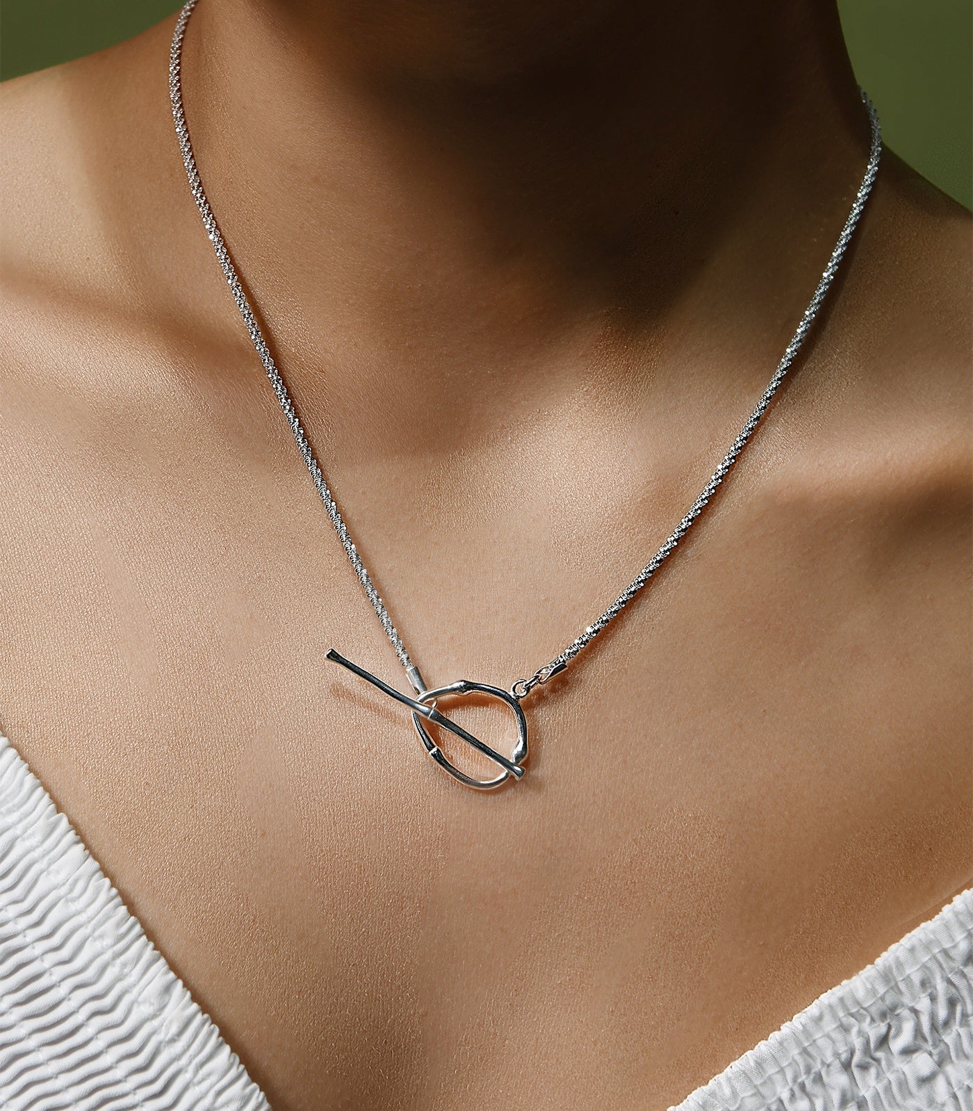 A sterling silver toggle clasp necklace. The toggle clasp is worn at the front.
