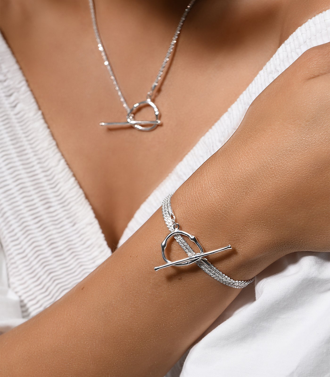 A shimmering sterling silver necklace and bracelet. Both pieces have a toggle clasp design as the main feature.