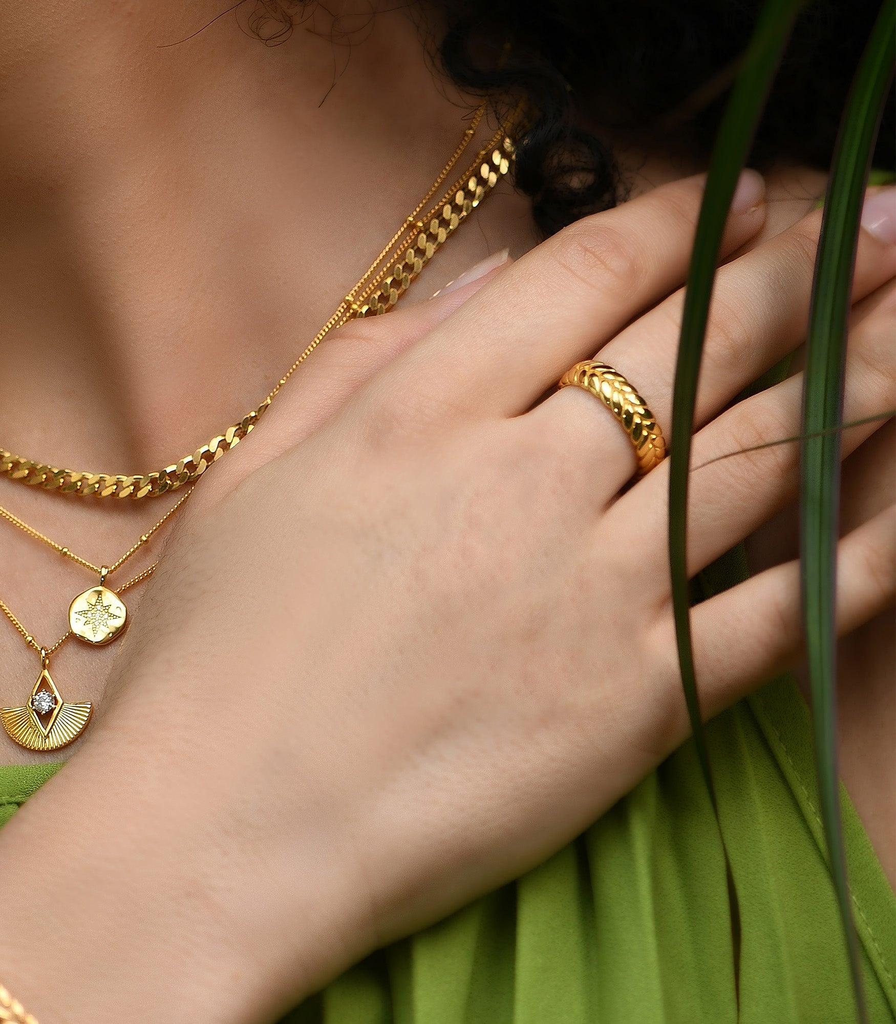 a female model wearing a chunky ring band featuring braid wheat pattern in gold